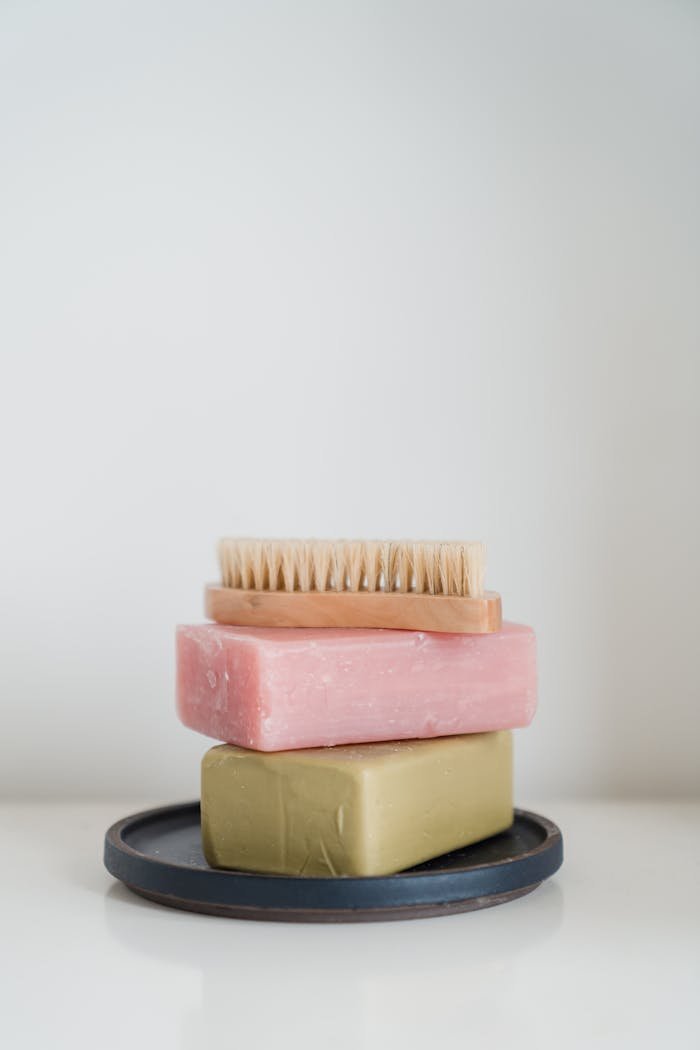 Minimalistic arrangement of soaps and body brush on a tray for personal care.